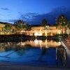 Piscina illuminata di notte con sedie a sdraio.