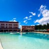 Una grande piscina vicino a un edificio rosa.
