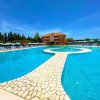 Piscina a sfioro con passerella centrale.
