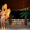 Una donna in costume arancione con piume, davanti a un pubblico.