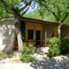 Bungalow con veranda ombreggiata da alberi.