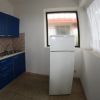 Cucina con mobili blu e frigorifero bianco.