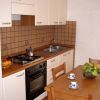 Cucina con piano cottura e tavolo con tazze.