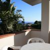 Terrazza con tavolo, sedie e vista mare.