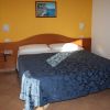 Letto matrimoniale in stanza con pareti gialle.