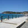 Spiaggia con mare e lungomare soleggiati.