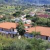 Complesso di case con tetti rossi, circondato da verde campagna.