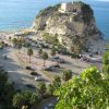 Promontorio roccioso con edificio, affacciato sul mare azzurro.