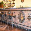 Bancone bar in mattoni con sgabelli alti.