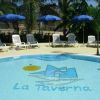 Piscina con sdraio e ombrelloni blu.