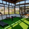 Palestra con attrezzi fitness, vista esterna soleggiata.
