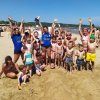 Gruppo di persone sorridenti sulla spiaggia.