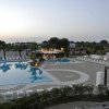 Ampia piscina con lettini bianchi.