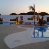 Ampio patio con piscina e lettini, al tramonto.
