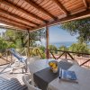 Terrazza coperta con tavolo, sedie e vista mare.