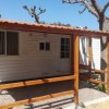 Bungalow bianco con veranda in legno.
