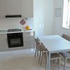 Cucina moderna con tavolo e sedie beige.