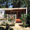 Bungalow con veranda e piante intorno.