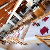 Interno di un ristorante con tavoli apparecchiati e soffitto in legno.