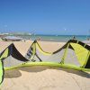 Spiaggia sabbiosa con aquilone volante giallo.
