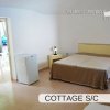 Interno di un cottage con letto matrimoniale.