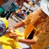 Donna in giallo dà un gioco a un bambino.
