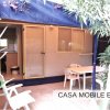 Veranda con tavolo e sedie tra piante.