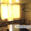 Interno di una casa mobile con divano ad angolo e tavolo.