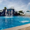Piscina con giochi d'acqua, scivoli e cielo sereno.