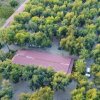 Costruzione con tetto rosso tra alberi fitti.