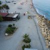 Spiaggia con bar, rocce e camper.