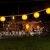 Spettacolo serale all'aperto con pubblico e luci decorative.