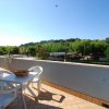 Terrazza con tavolo, sedie e vista su alberi.