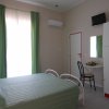 Camera d'albergo con letto matrimoniale, armadio e TV.