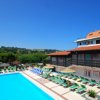 Piscina con lettini colorati e ombrelloni.