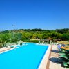 Piscina all'aperto con lettini e ombrelloni colorati.