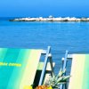 Sedie a sdraio fronte mare con frutta su un tavolino.