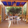 Veranda con tavolo e sedie sotto tettoia blu.