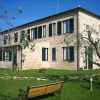 Casa di mattoni con giardino e panchina.