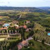 Vista aerea di un complesso turistico in campagna con piscine e campi immersi nel verde.