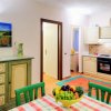 Cucina colorata con tavolo apparecchiato, mobili in legno e dipinto floreale alle pareti.