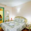 Una camera da letto con letto matrimoniale, copriletto patchwork e due finestre con tende blu.