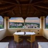 Vista da un portico coperto con tavolo e sedie, affacciato su un panorama collinare al tramonto.