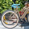 Biciclette parcheggiate con sellini blu decorati e ruote di colore chiaro.