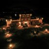 Edificio di notte con luci calde e giardino illuminato.