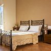 Camera da letto con due letti singoli in ferro, comodino in legno e finestra aperta.