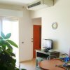 Interno di un appartamento con tavolo apparecchiato, pianta e piccolo televisore.
