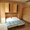 Una camera da letto con un letto a due piazze, armadi di legno chiaro e una coperta a quadri.