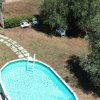Piscina ovale con sentiero di pietra accanto.