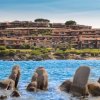 Case su colline vicino al mare e scogli.
